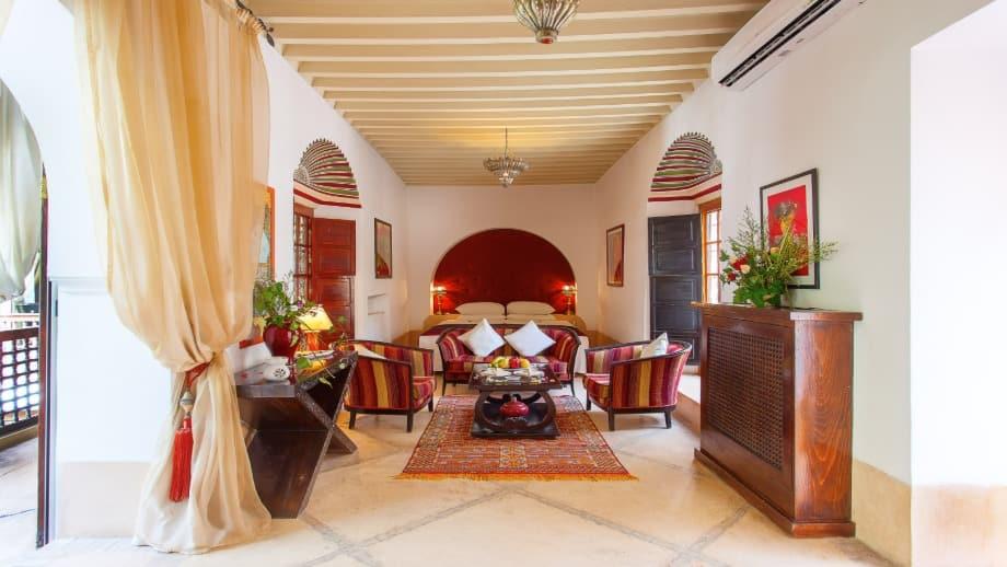Luxurious seating with cushions adorns a cozy living room featuring vibrant decor at Angsana Riads Collection - Marrakech, Si Said Suite.
