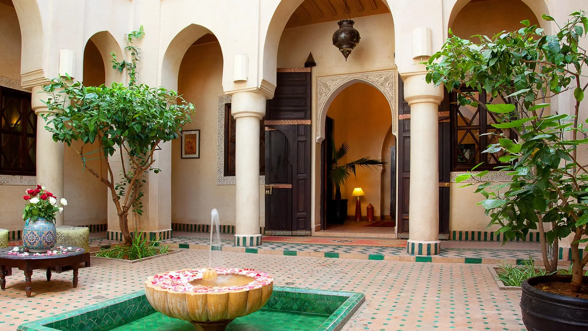 Fountain splashing in courtyard with plants, arches at Angsana Riads Collection - Marrakech, Riad Dar Zaouia.