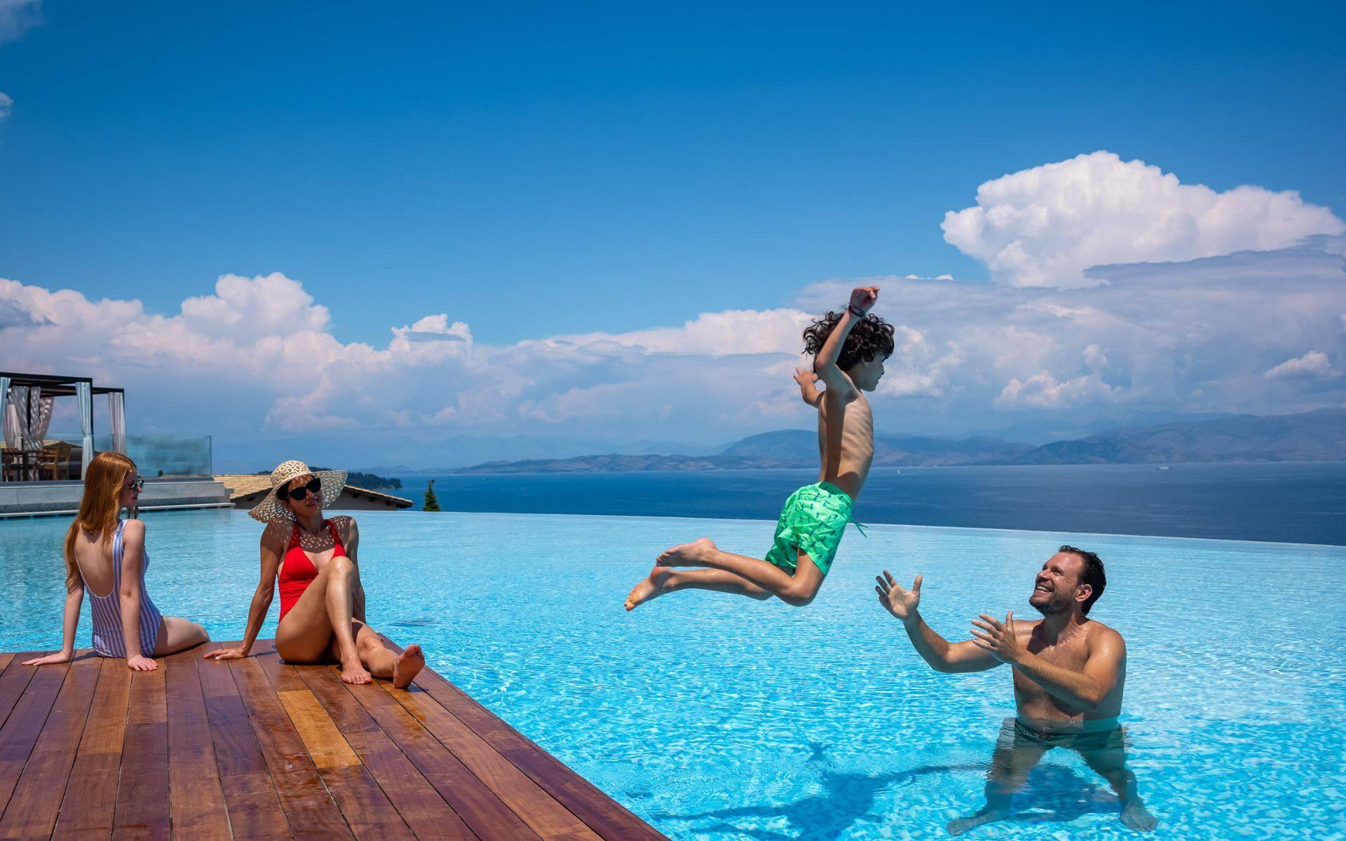 family playing in infinity pool  