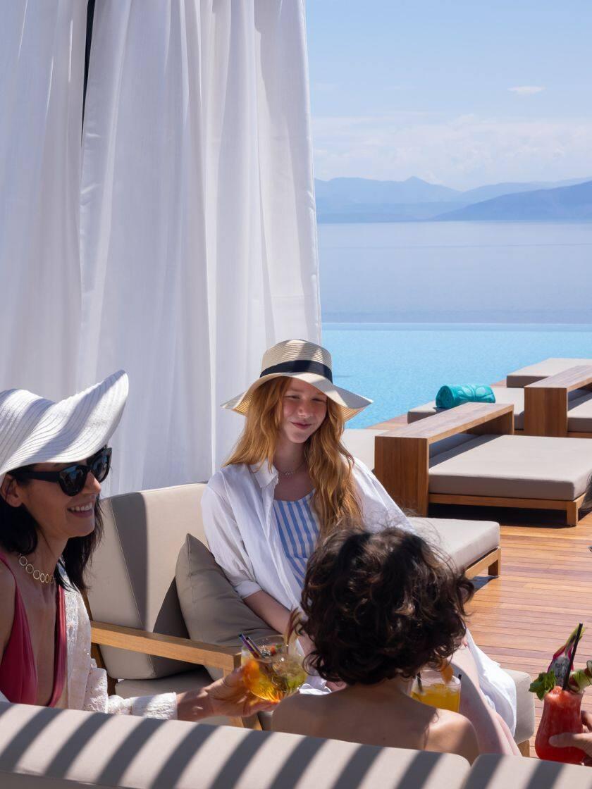 Family enjoying fresh juice by the infinity pool