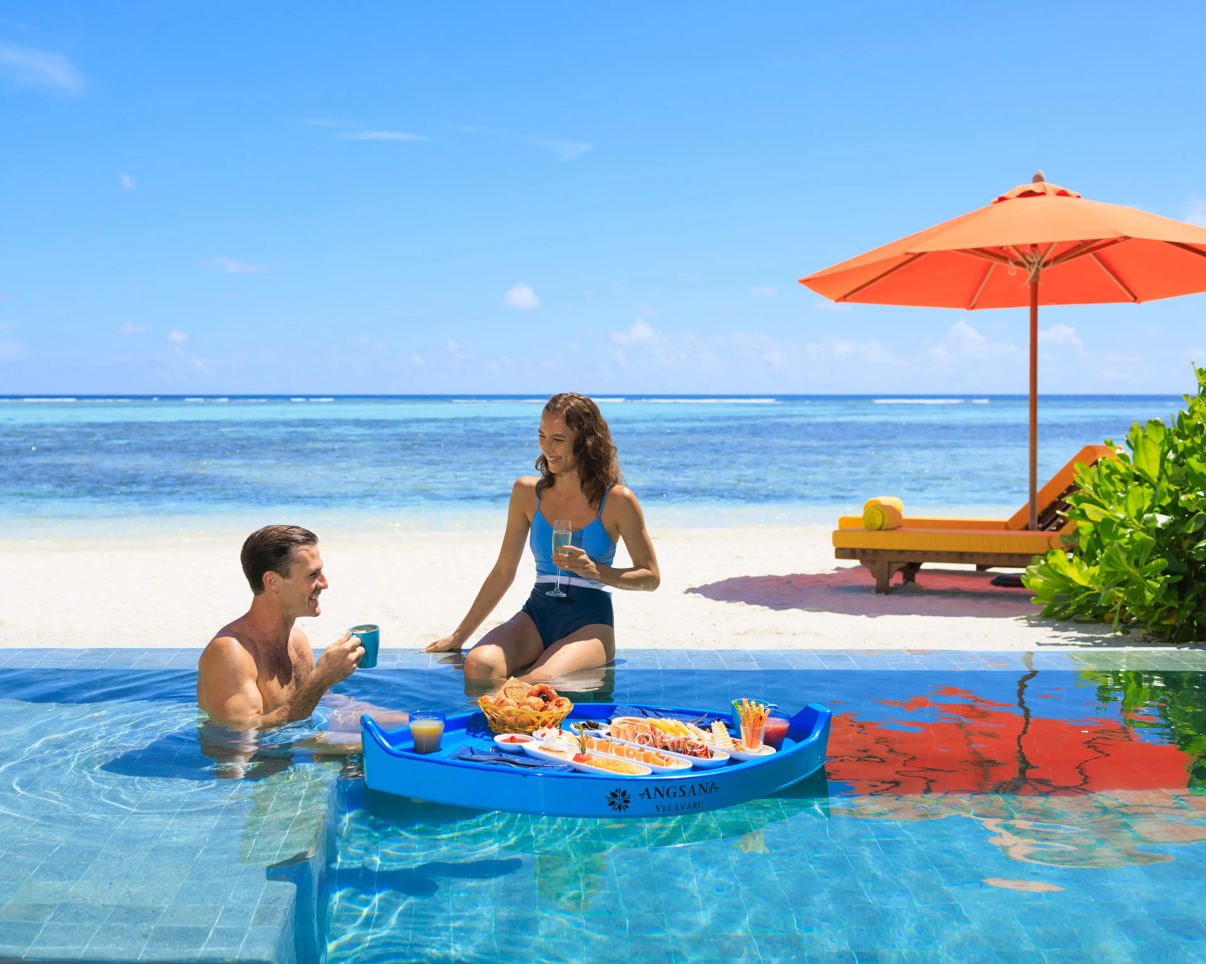 Unforgettable love story in the Maldives: A honeymoon couple embraces paradise at Angsana Velavaru, their love reflected in the endless ocean and luxurious surrounds.