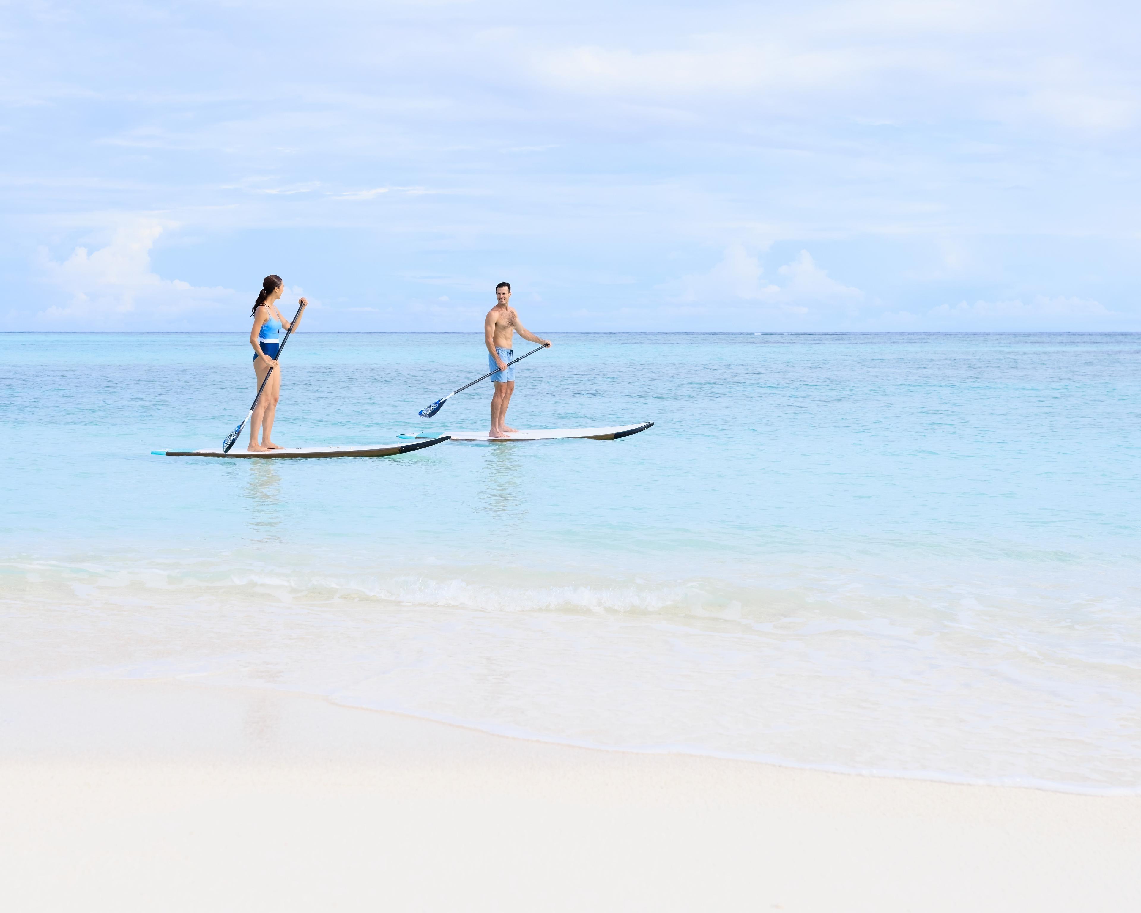 Unforgettable love story in the Maldives: A honeymoon couple embraces paradise at Angsana Velavaru, their love reflected in the endless ocean and luxurious surrounds.