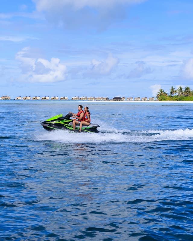 Couple riding Jet Ski in Sunny Maldives at Angsana Velavaru