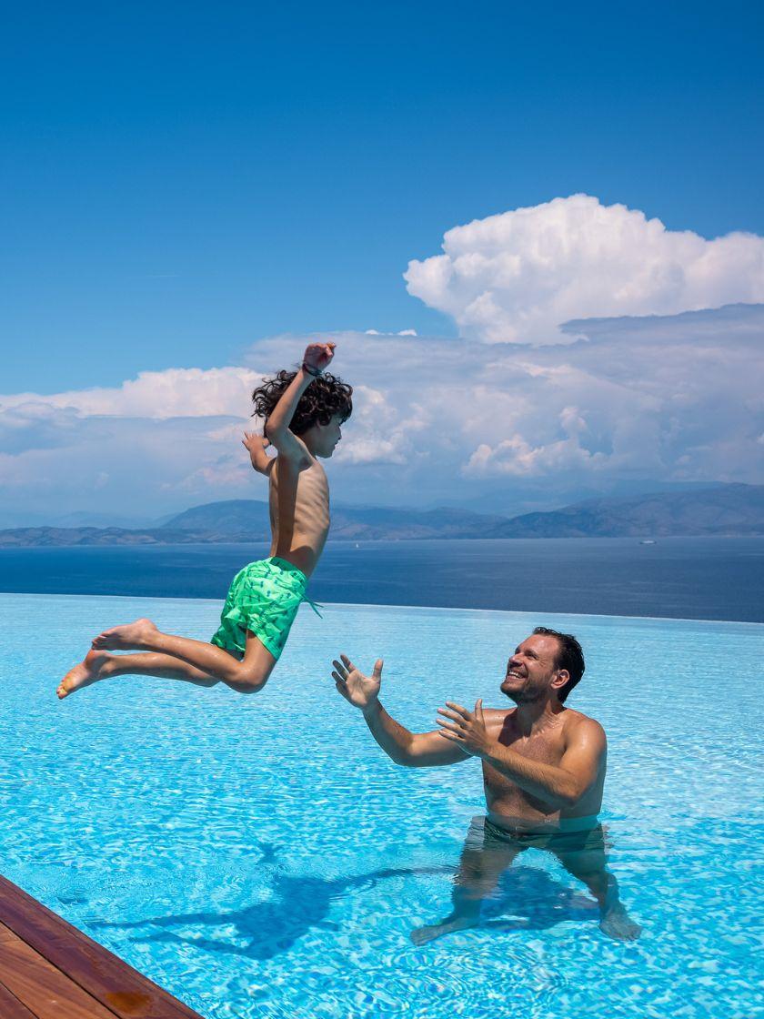 dad playing with his son at the infinity pool of Angsana Corfu 