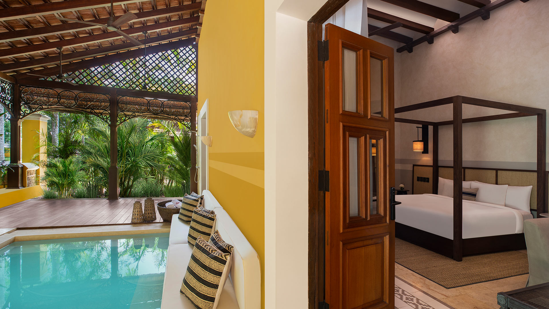 Poolside seating near lush plants, adjacent to a cozy bedroom at Hacienda Xcanatun, Angsana Heritage Collection.