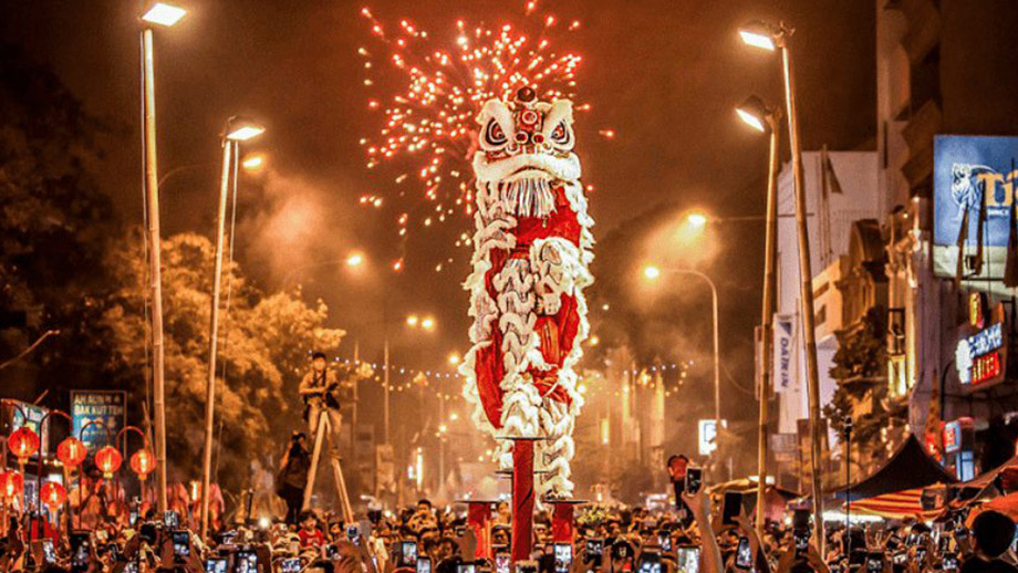 Lion dance performs amid fireworks at a vibrant street festival near Angsana Teluk Bahang Penang.
