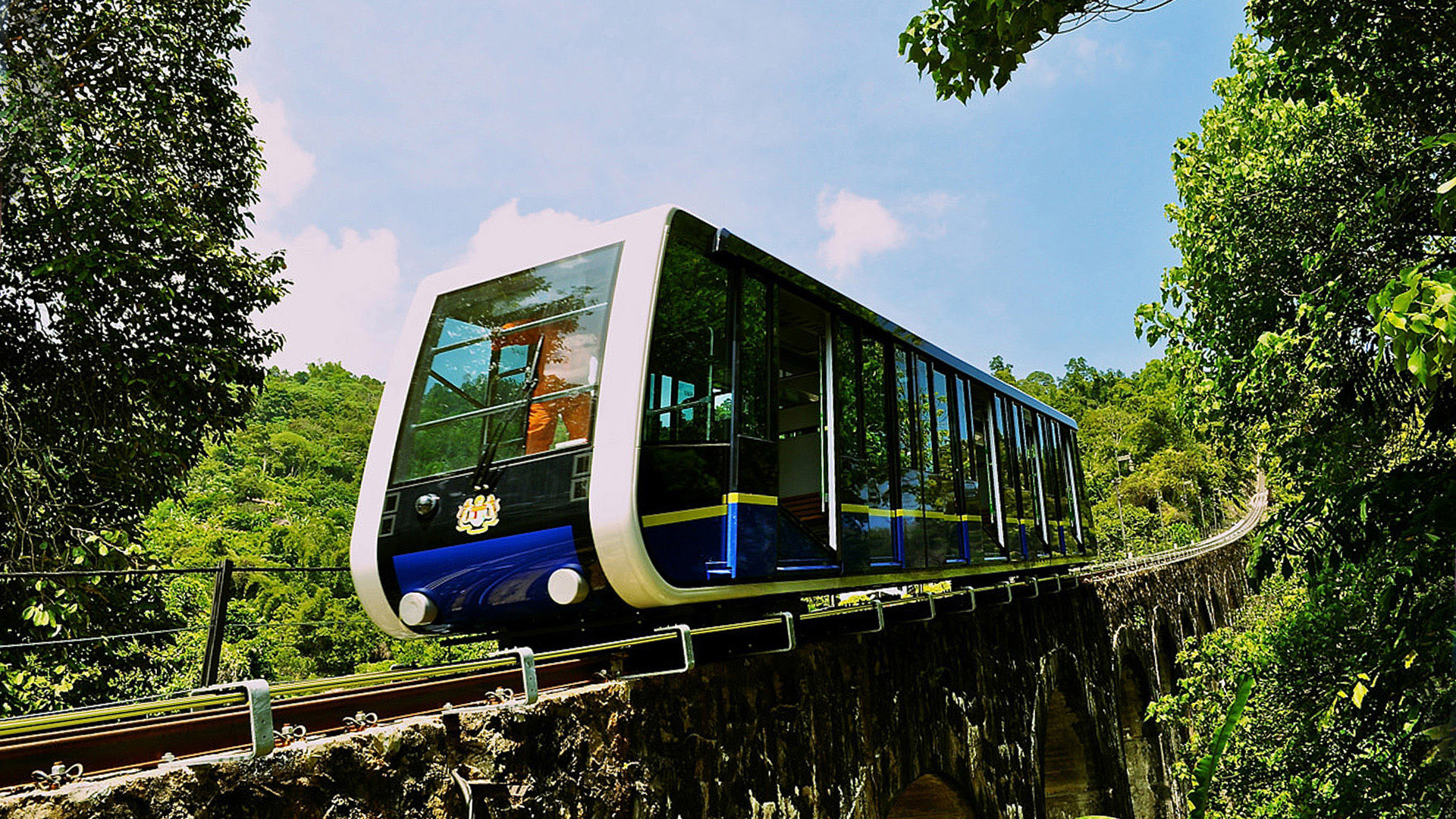 Funicular train travels on a track through lush greenery, Angsana Teluk Bahang Penang.