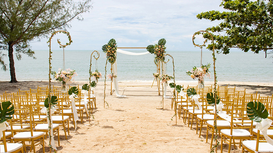 Beachfront wedding setup with chairs and floral arch at Angsana Teluk Bahang Penang.