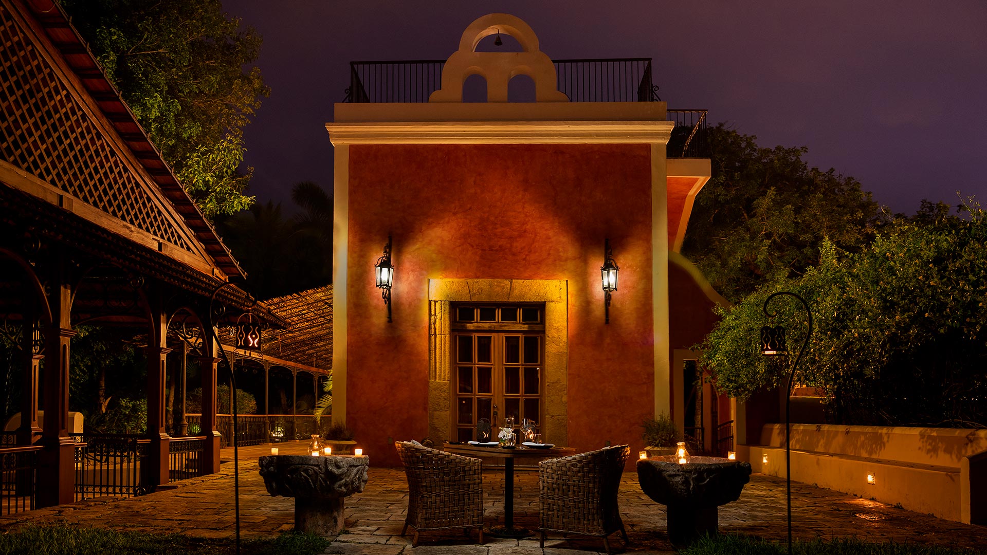 Courtyard dining setup at night, Hacienda Xcanatun, Angsana Heritage Collection, with warm lighting.
