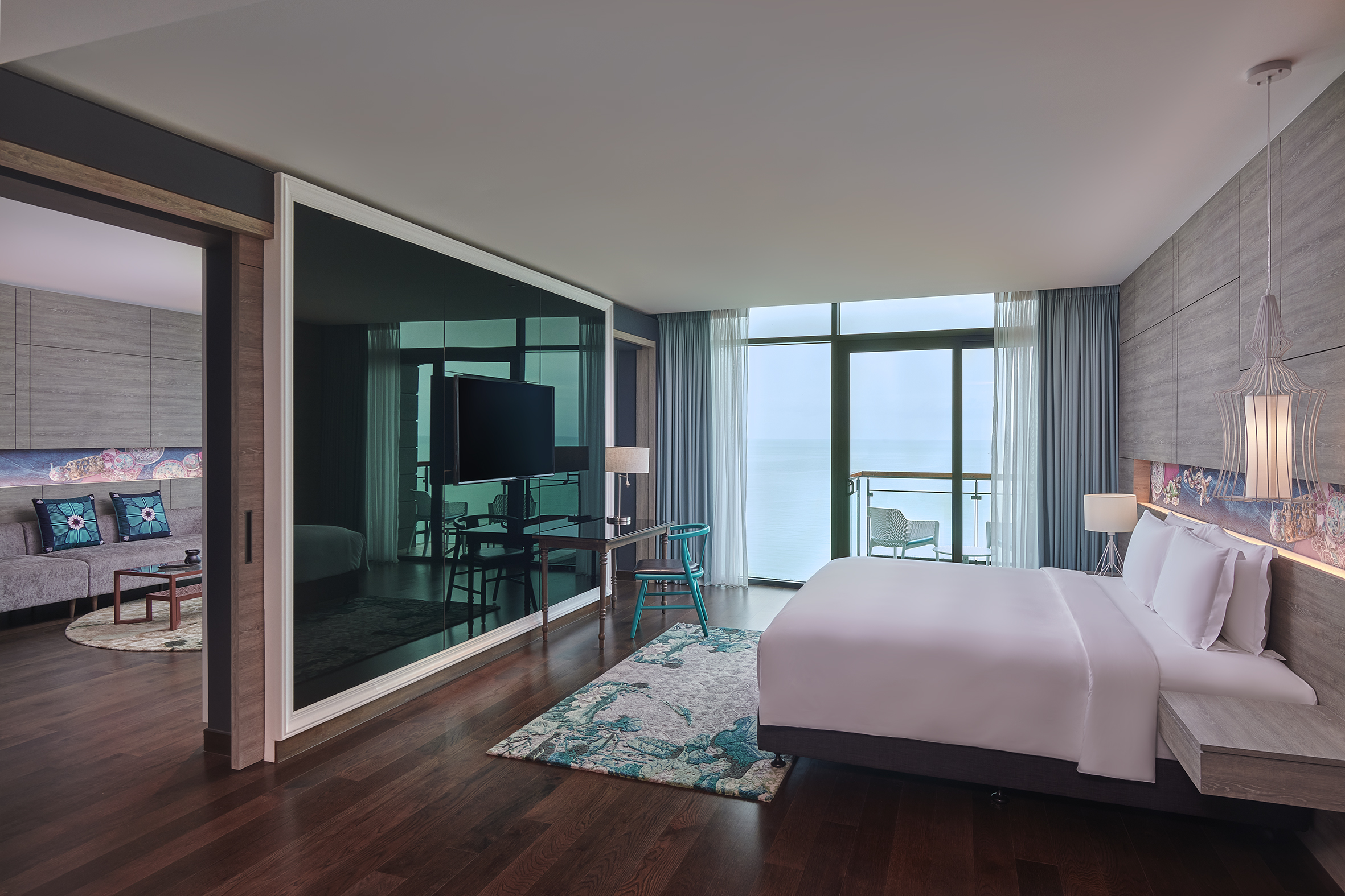 Elegant hotel suite with a bed and sofa, overlooking the sea at Angsana Teluk Bahang Penang.