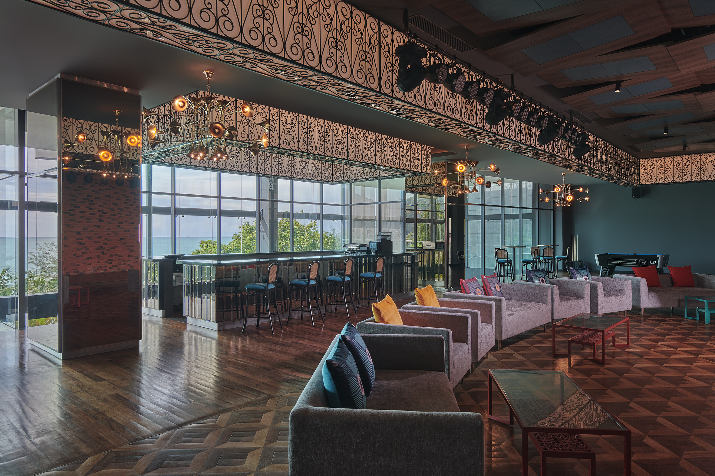 Contemporary lounge with sofas and bar seating overlooking ocean at Angsana Teluk Bahang Penang.