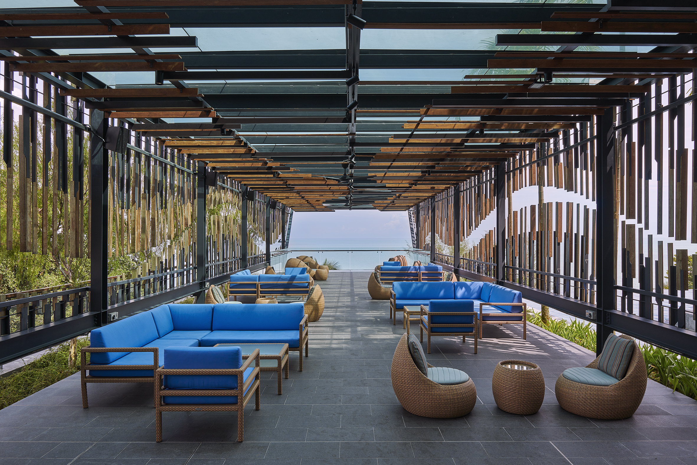 Outdoor lounge with blue sofas facing the sea at Angsana Teluk Bahang Penang.