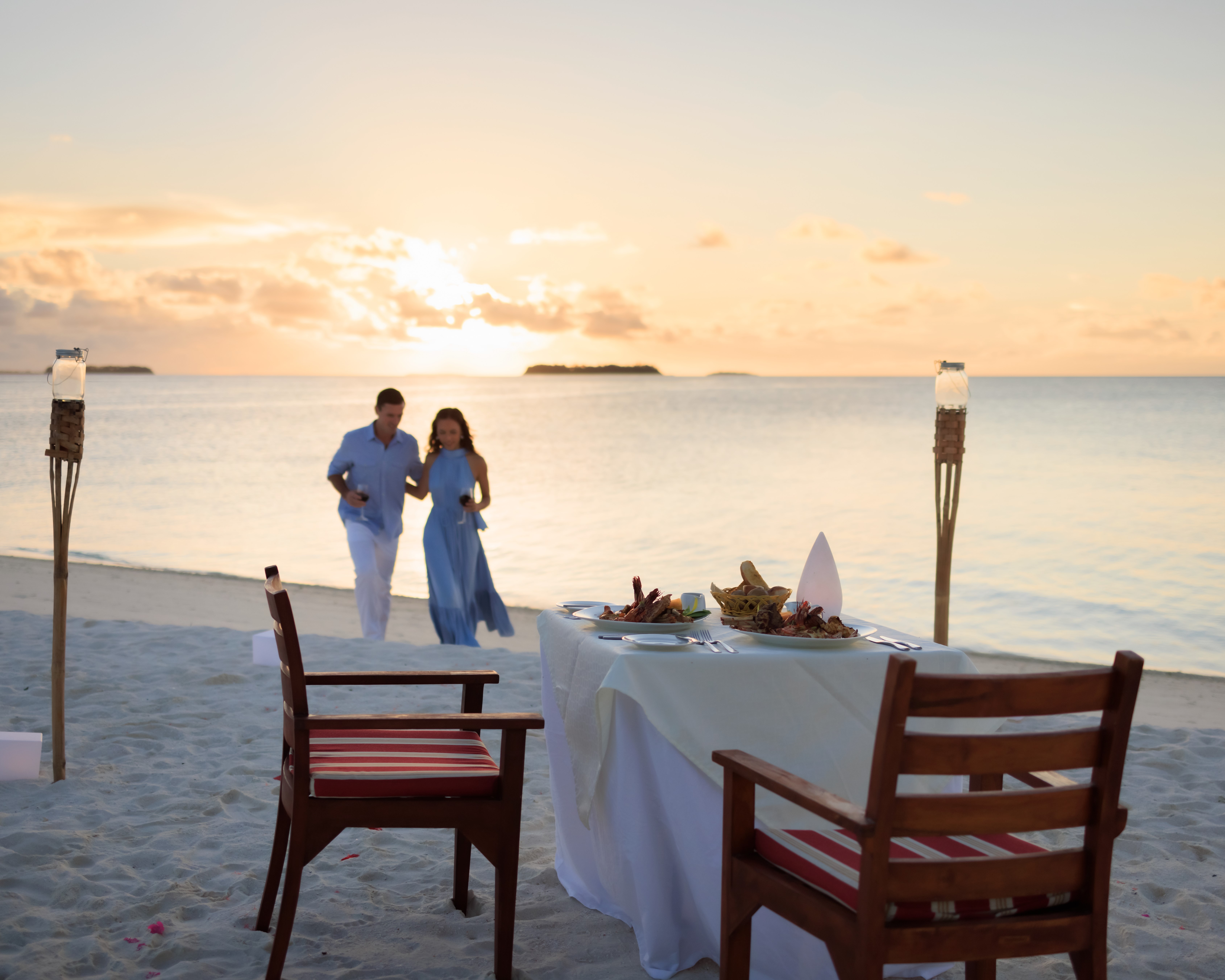 Unforgettable love story in the Maldives: A honeymoon couple embraces paradise at Angsana Velavaru, their love reflected in the endless ocean and luxurious surrounds.