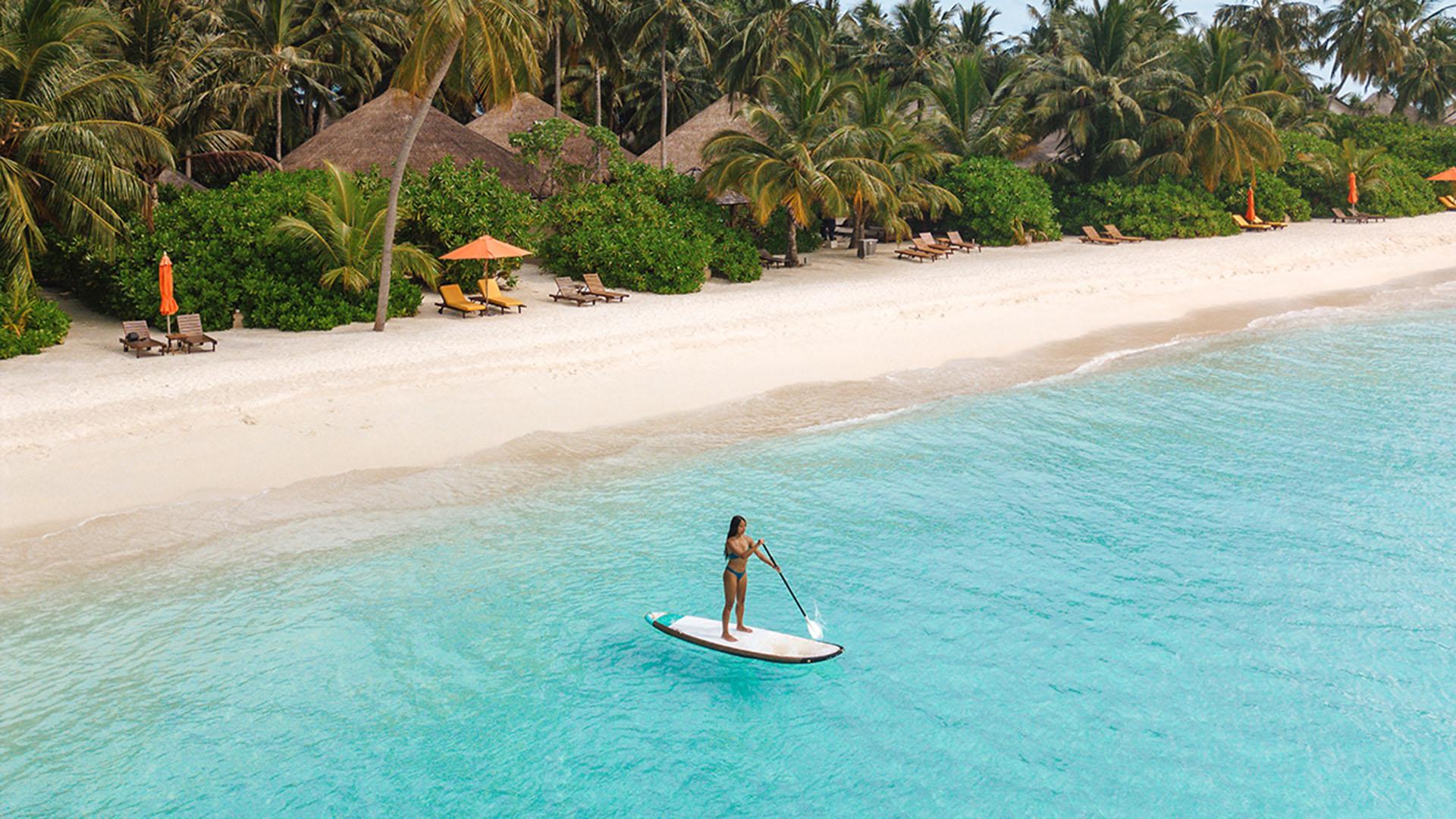 Stand-up paddleboarding adventure in the Maldives at Angsana Velavaru. Explore crystal-clear waters and discover the beauty of the resort.